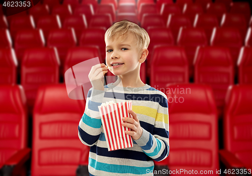 Image of smiling boy eating popcorn at movie theater