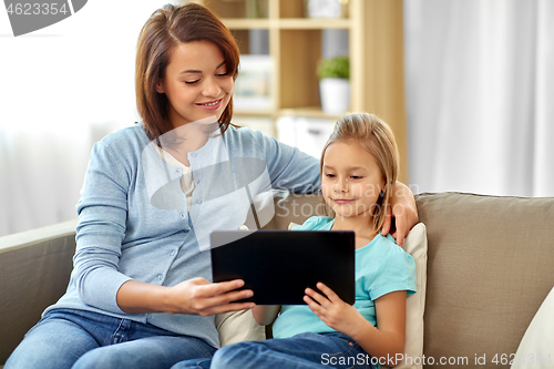 Image of happy mother and daughter with tablet pc at home