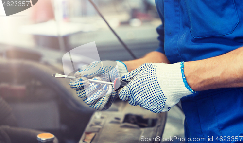 Image of mechanic man with wrench repairing car at workshop