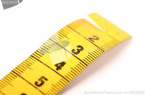 Image of Close-up of a yellow measuring tape isolated on white - 3