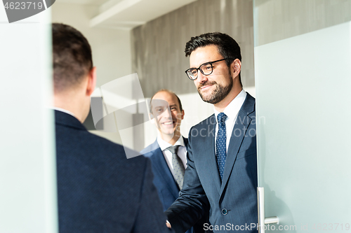 Image of Group of confident business people greeting with a handshake at business meeting in modern office or closing the deal agreement by shaking hands.