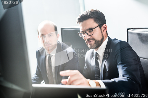 Image of Business team analyzing data at business meeting in modern corporate office.