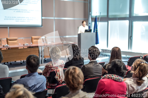 Image of Woman giving presentation in lecture hall at university.