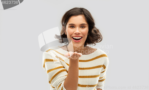 Image of smiling woman holding something on empty palm