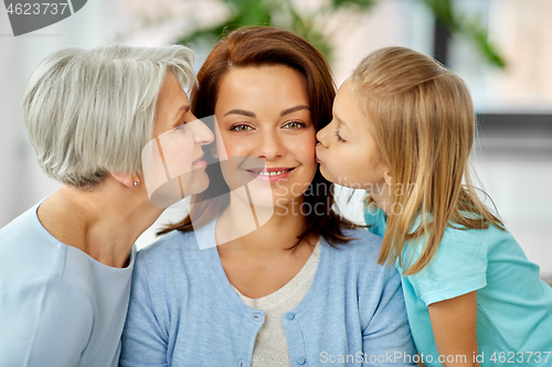 Image of mother and daughter kissing happy grandmother