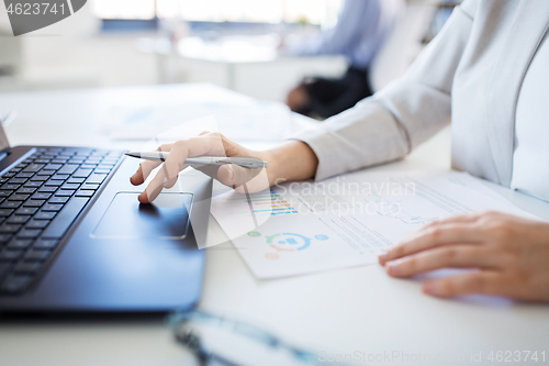 Image of businesswoman with laptop working at office