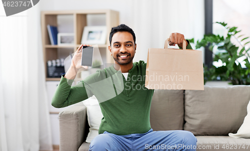 Image of indian man using smartphone for food delivery