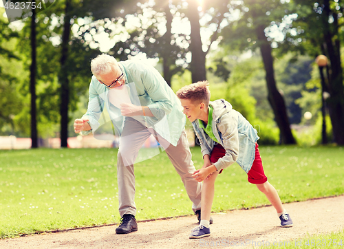 Image of grandfather and grandson racing at summer park