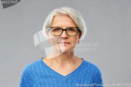 Image of portrait of senior woman in glasses over grey