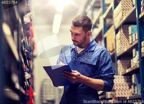 Image of auto mechanic with clipboard at car workshop