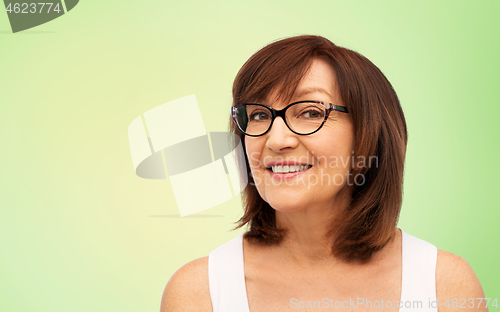 Image of portrait of senior woman in glasses over blue