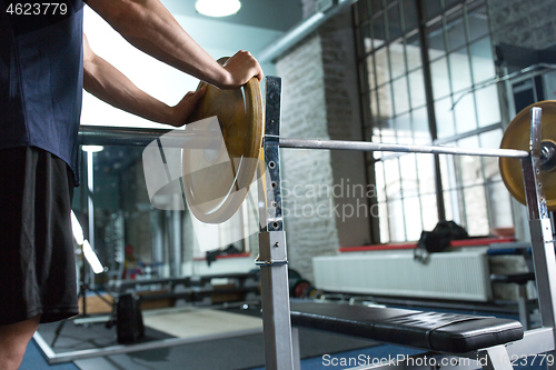 Image of close up of man with barbell weight in gym