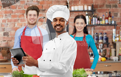 Image of male indian chef with tablet pc at cooking class