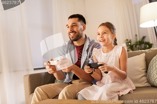 Image of father and daughter playing video game at home