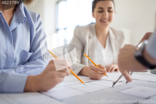 Image of close up of architects with blueprint at office