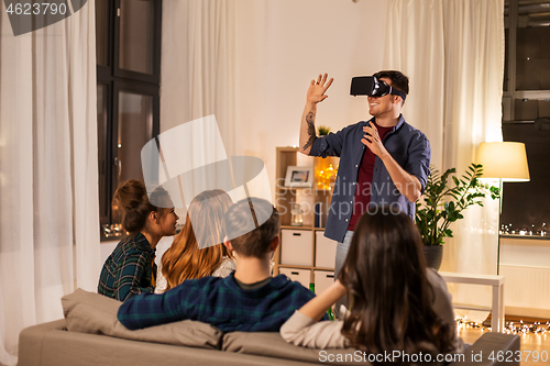 Image of man in vr glasses at home with friends