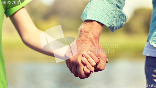 Image of senior man and child holding hands