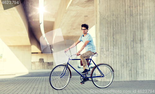 Image of young hipster man riding fixed gear bike