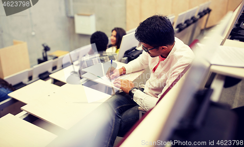 Image of group of students with notebooks in lecture hall