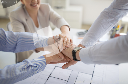 Image of close up of business team stacking hands