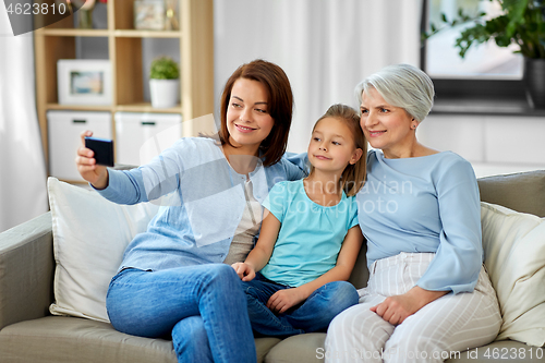 Image of mother, daughter and grandmother taking selfie