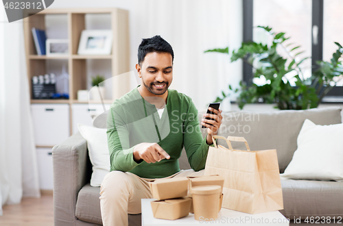 Image of indian man using smartphone for food delivery
