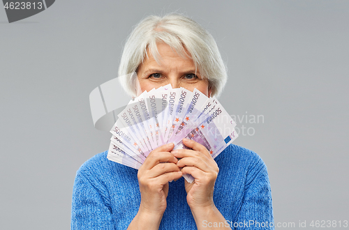 Image of senior woman with hundreds of euro money banknotes