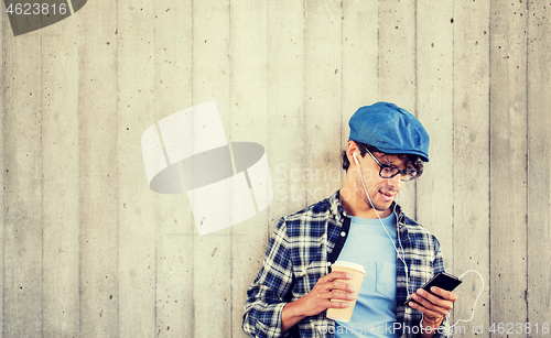 Image of man with earphones and smartphone drinking coffee