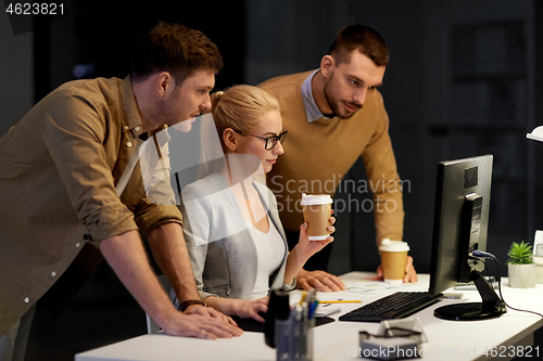 Image of business team with computer working late at office