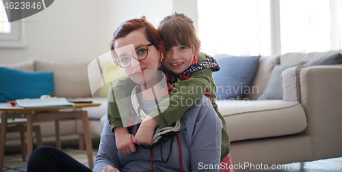 Image of Mother and little girl daughter playing with jewelry  at home