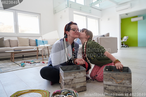 Image of Mother and little girl daughter playing with jewelry  at home