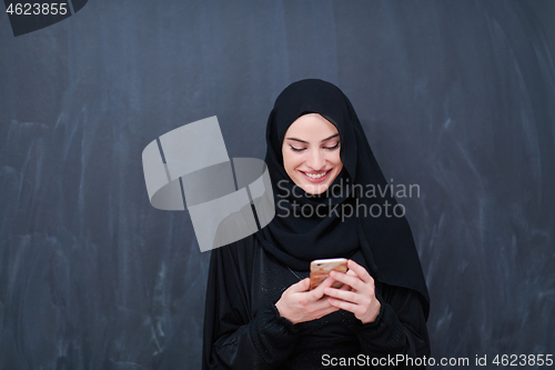 Image of young modern muslim business woman using smartphone