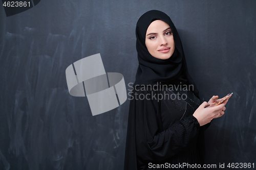 Image of young modern muslim business woman using smartphone