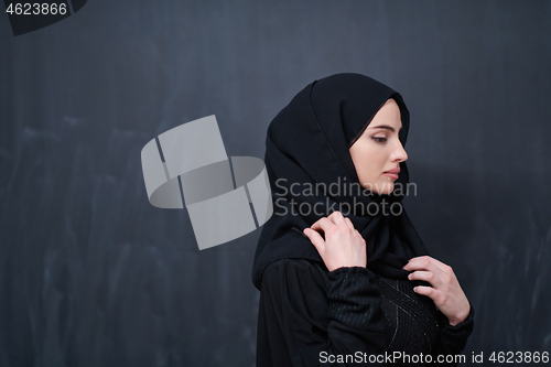 Image of portrait of beautiful muslim woman in front of black chalkboard