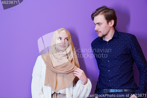 Image of portrait of young muslim couple isolated on purple background