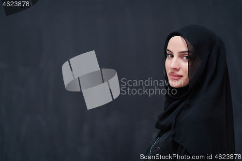 Image of portrait of beautiful muslim woman in front of black chalkboard