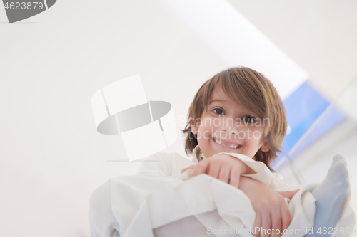 Image of portrait of little arabian boy sitting on the glass floor