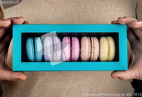 Image of Closeup macaroons in gift box in hands