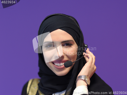 Image of portrait of muslim woman with headset on purple background