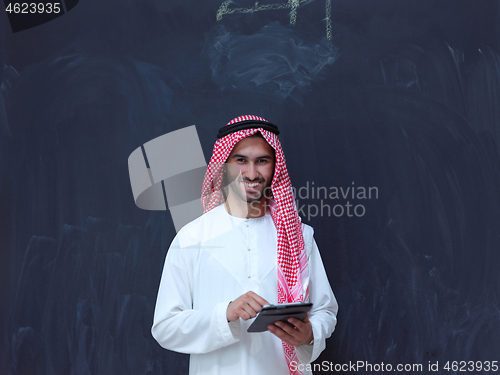 Image of young arabian muslim businessman using tablet computer