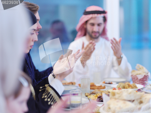 Image of traditional muslim family praying before iftar dinner