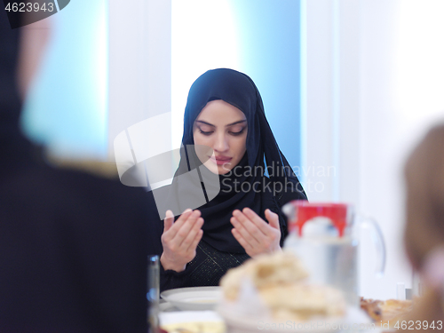 Image of muslim woman making traditional prayer to God before iftar dinne