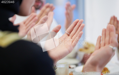 Image of traditional muslim family praying before iftar dinner