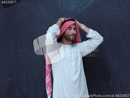 Image of portrait of arabian man in front of black chalkboard