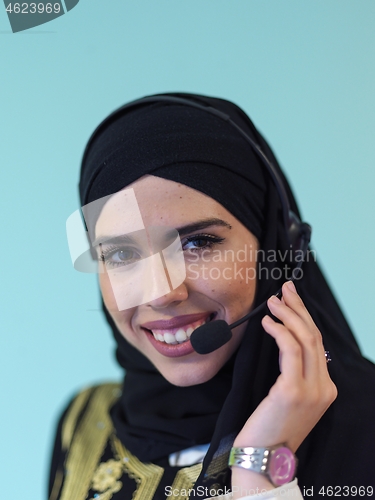 Image of muslim woman with headset on cyan background