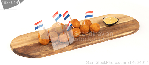 Image of Dutch traditional snack bitterbal on a serving board, dutch flag