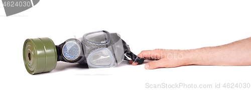 Image of Arm reaching for vintage gasmask isolated on white - Green filte