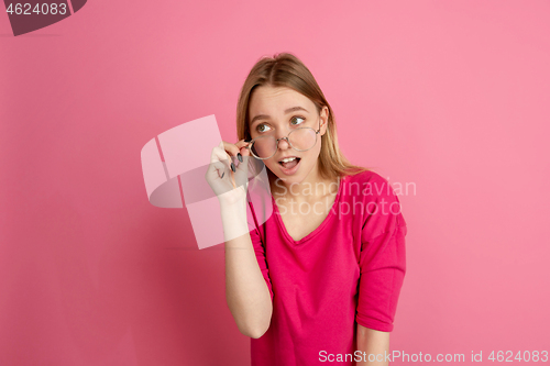 Image of Caucasian young woman\'s monochrome portrait on pink studio background, emotinal and beautiful