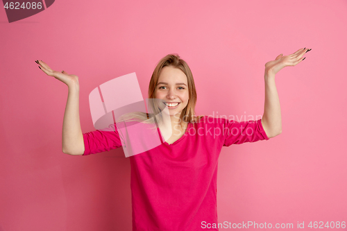 Image of Caucasian young woman\'s monochrome portrait on pink studio background, emotinal and beautiful