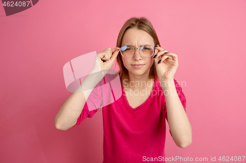 Image of Caucasian young woman\'s monochrome portrait on pink studio background, emotinal and beautiful